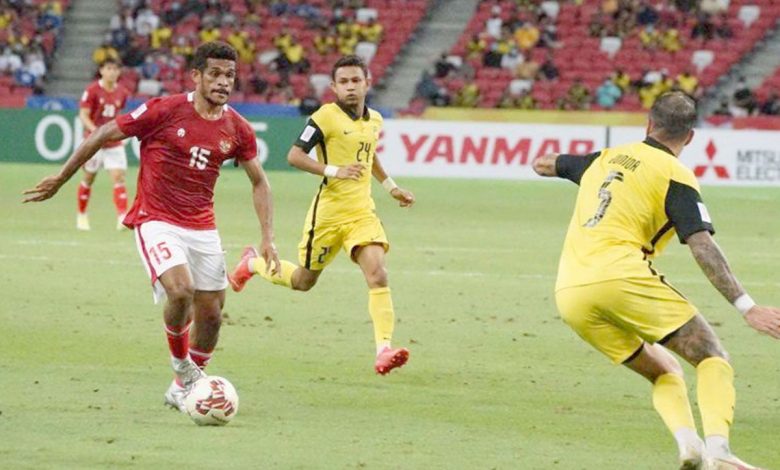 Pesepak bola Timnas Indonesia Ricky Kambuaya (kiri) berusaha melewati pesepak bola Timnas Malaysia Putera Nadher (kanan) dalam pertandingan grup B Piala AFF 2020 di National Stadium, Singapura