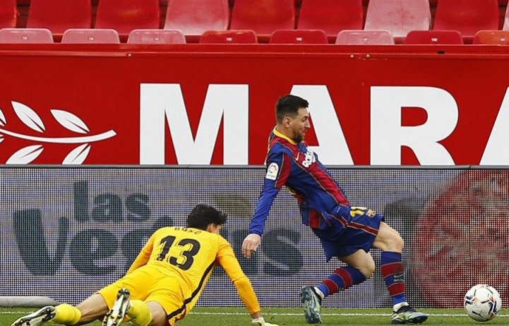 Megabintang Barcelona Lionel Messi (kanan) mengecoh kiper Sevilla Bono sebelum mencetak gol kedua timnya dalam laga lanjutan Liga Spanyol di Stadion Ramon Sanchez Pizjuan, Sevilla, Spanyol, Sabtu (27/2/2021). Foto : Antara/Reuters/Marcelo del Pozo)