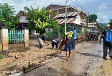 Masyarakat bekerja bakti membersihkan lumpur dan batang pohon yang menutup Jalan Trans Lite, Waiwerang Kota, Rabu (7/4/2021). Foto : Antara/Andi Firdaus