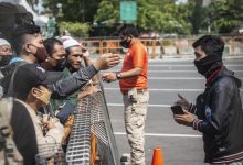 Petugas memberikan imbauan kepada warga yang akan berwisata untuk kembali pulang di depan pintu masuk Ancol Taman Impian, Jakarta, Sabtu (15/5/2021). Foto : Antara/Aprillio Akbar/wsj.