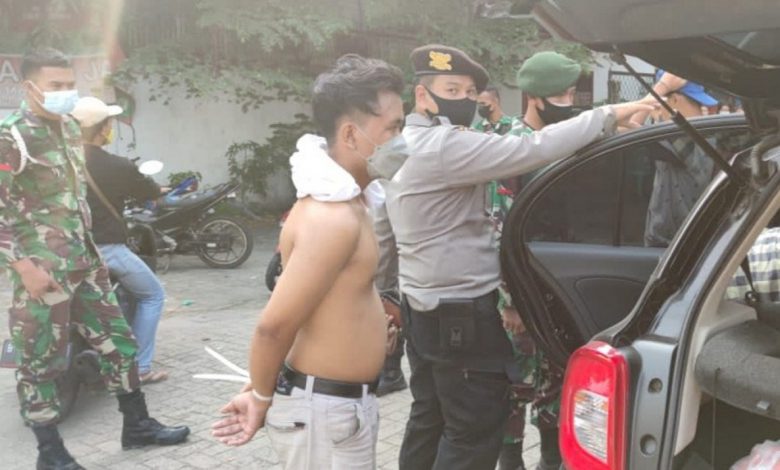 Tersangka penjambretan NS (28) saat dikawal petugas menuju Polres Metro Jakarta Barat usai berupaya menabrak petugas di Pos Penyekatan Kalideres, Jakarta Barat, Minggu (18/7/2021). Foto : Antara/HO-Humas Polres Metro Jakarta Barat