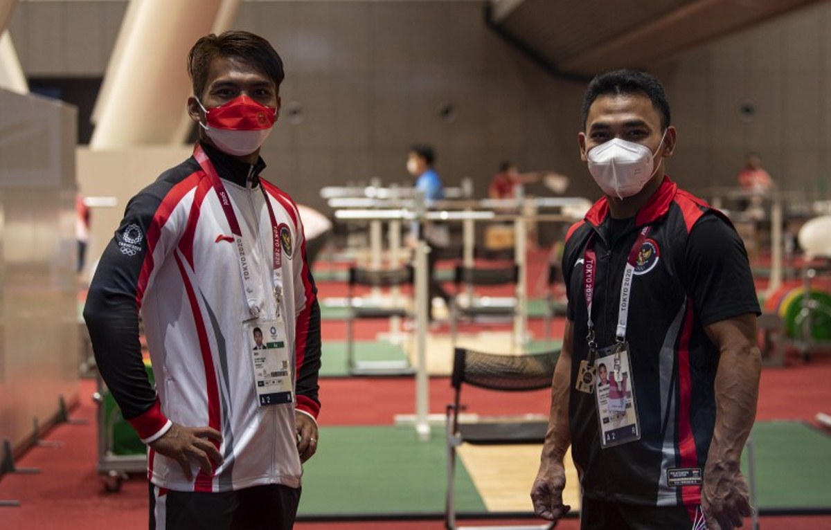 Lifter Indonesia Eko Yuli Irawan (kanan) dan Deni berpose seusai berlatih di Hall Tokyo International Forum, Tokyo, Rabu (21/7/2021). Foto : Antara /Sigid Kurniawan