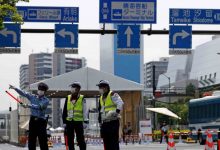 Petugas kepolisian dan keamanan berjaga di pintu masuk wisma atlet menjelang penyelenggaraan Olimpiade Tokyo 2020, Selasa (13/7/2021). Foto : Antara/Reuters/Issei Kato/wsj.