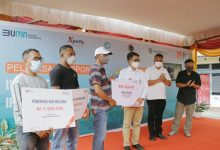 Wakil Pemimpin Bank Negara Indonesia (BNI) Wilayah 06 - Denpasar, Mustakim (ketiga kanan) menyerahkan secara simbolis kredit usaha rakyat (KUR) Nelayan serta fasilitas Agen46 pada nelayan di Maumere, Nusa Tenggara Timur, Sabtu (30/10). Foto: BNI