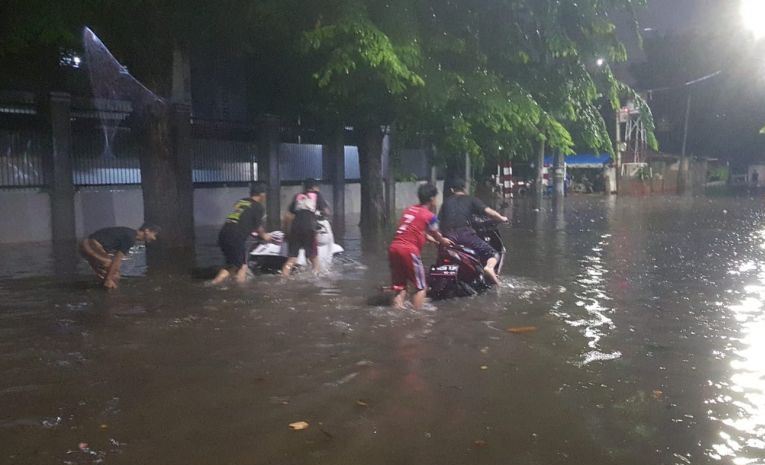 Pengendara Motor Melintas Di Jalan Yang Tergenang Banjir Di Pulogadung, Jakarta, Jumat (12/11/2021). Foto : Antara/Yogi Rachman