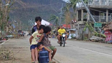 Anak-anak naik kereta darurat di dekat jalan yang rusak di Provinsi Surigao del Norte, Filipina, Sabtu (18/12/2021). Foto : Antara /Philippine Coast Guard/Handout via Reuters/rwa.