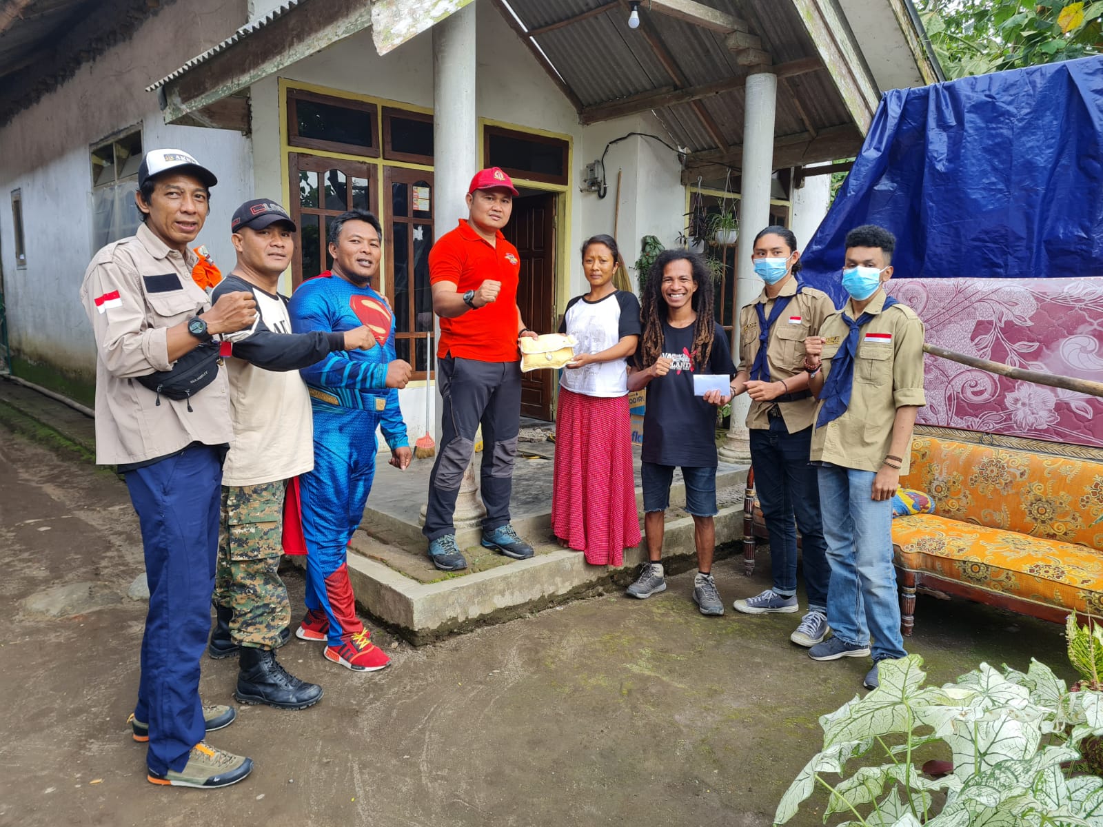 Koordinator Tim Relawan Korban Semeru dari AKBM (Anak Korps Baret Merah) Susilo (empat kiri) memberikan bantuan kepada sorang ibu yang suaminya mengalami luka bakar akibat terkena awan panas Semeru. Foto : AKBM