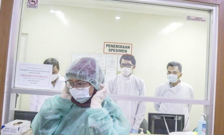 Petugas medis mengenakan pakaian steril saat akan memasuki Labotarium Badan Penelitian dan Pengembangan Kesehatan (Balitbangkes) di Jakarta