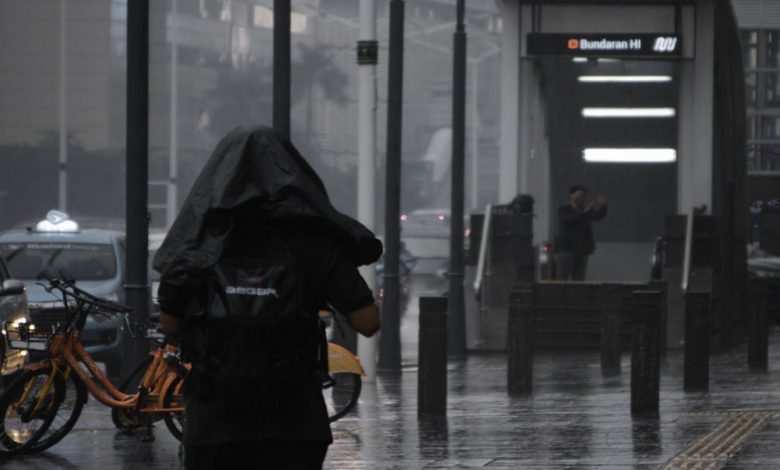 Seseorang berjalan di tengah hujan. Foto: Antara