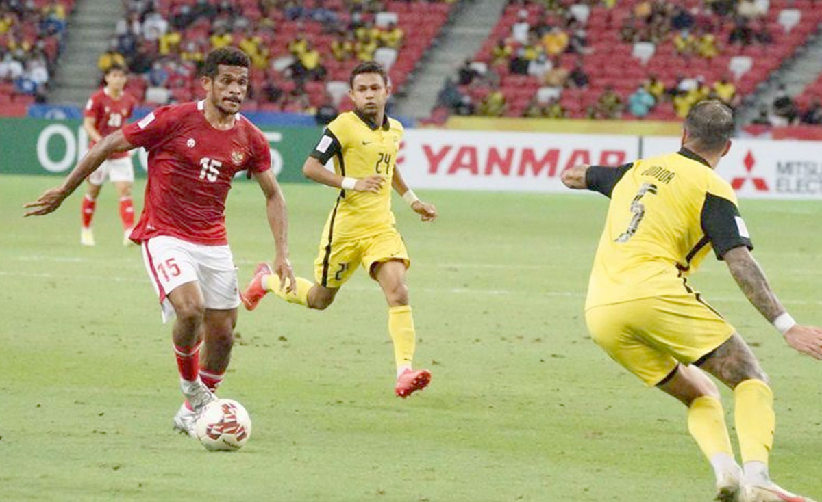 Pesepak bola Timnas Indonesia Ricky Kambuaya (kiri) berusaha melewati pesepak bola Timnas Malaysia Putera Nadher (kanan) dalam pertandingan grup B Piala AFF 2020 di National Stadium, Singapura