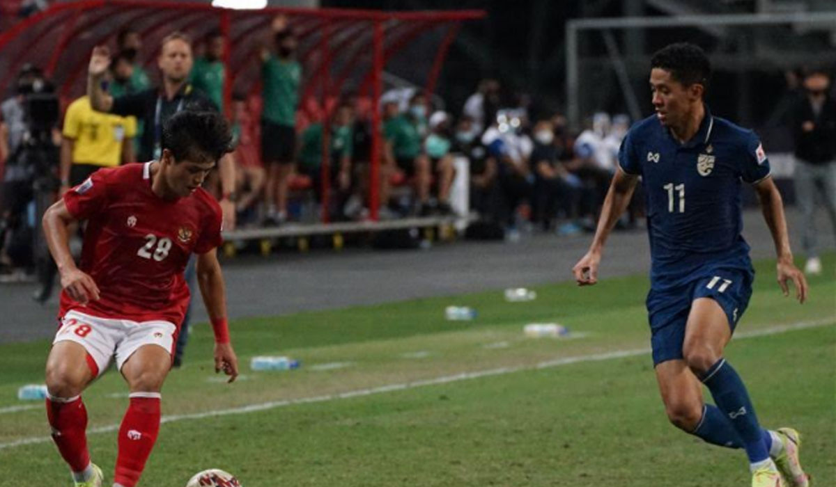 Bek tim nasional Indonesia Alfeandra Dewangga( kiri) menggiring bola dalam pengawasan pemain Thailand Bordin Phala dalam laga leg pertama final Piala AFF 2020 di Stadion Nasional, Singapura, Rabu (29/12/2021). Indonesia kalah 0-4 pada pertandingan tersebut