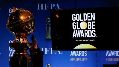 Seseorang Memegang Telepon Di Samping Patung Golden Globe Sebelum Pengumuman Nominasi Golden Globe Awards Ke-79 Di Beverly Hills, California, As, 13 Desember 2021