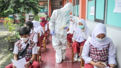 Petugas kesehatan memberikan nomor antrean kepada siswa untuk menjalani pemeriksaan Covid-19 di Sekolah Dasar Negeri (SDN) 025 Cikutra, Bandung, Jawa Barat, Jumat (22/10/2021)