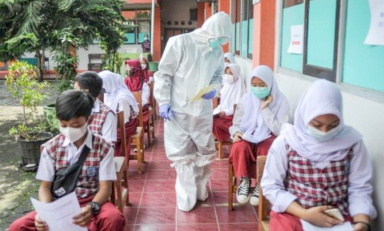 Petugas kesehatan memberikan nomor antrean kepada siswa untuk menjalani pemeriksaan Covid-19 di Sekolah Dasar Negeri (SDN) 025 Cikutra, Bandung, Jawa Barat, Jumat (22/10/2021)