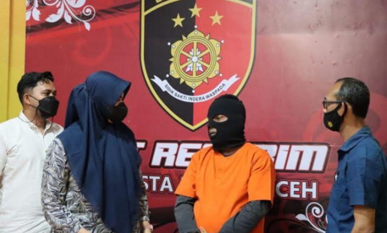 Terduga pelaku pemerkosa dan pelecehan seksual terhadap anak tirinya berinisial SB (baju oranye) saat ditanyai oleh kepolisian, di Mapolresta Banda Aceh, Kamis (6/1/2022)