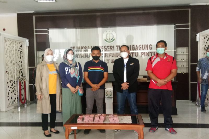Tersangka AK (dua dari kiri, kaos biru dan berkacamata), selepas pengembalian uang hasil dugaan korupsi proyek Dinas PUPR Tulungagung di Kejaksaan Negeri Tulungagung. Antara/ho/Kejaksaan Negeri Tulungagung