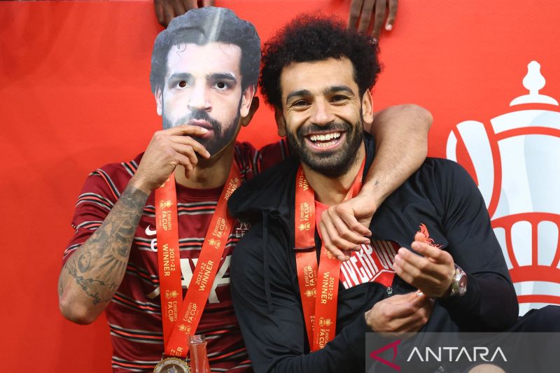 Pemain Liverpool, Thiago Alcantara memakai topeng Mohamed Salah di sebelahnya saat merayakan kemenangan Liverpool pada final FA Cup Chelsea vs Liverpool di Wembley Stadium, London, Inggris, Sabtu (14/5/2022). Foto : Antara/Reuters/Hannah Mckay/foc/sad.