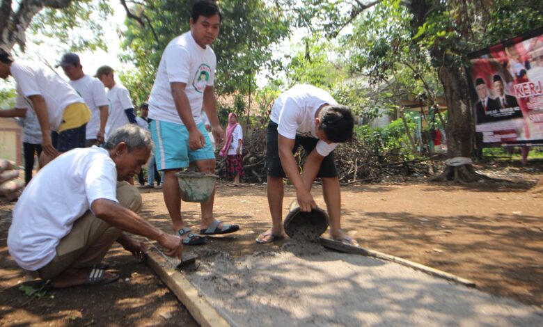 Foto : Santri Dukung Ganjar Gotong Royong Bareng Warga Renovasi Jalan di Desa Klapanunggal